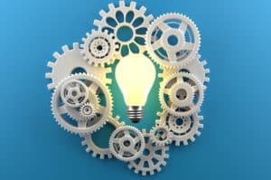Cogs surrounding a lightbulb. Indicating knowledge or understanding. 